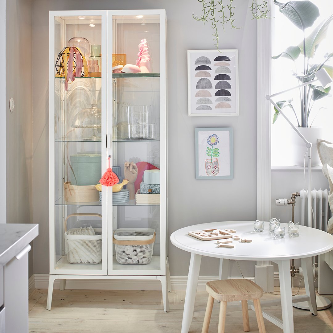 A white MILSBO glass-door cabinet in the living room