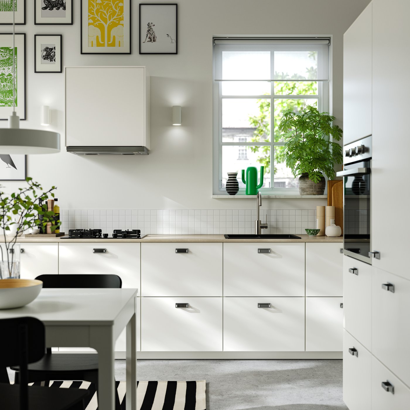 Een witte keuken in Scandinavische stijl met zwarte handgrpen en een natuurlijk werkblad.