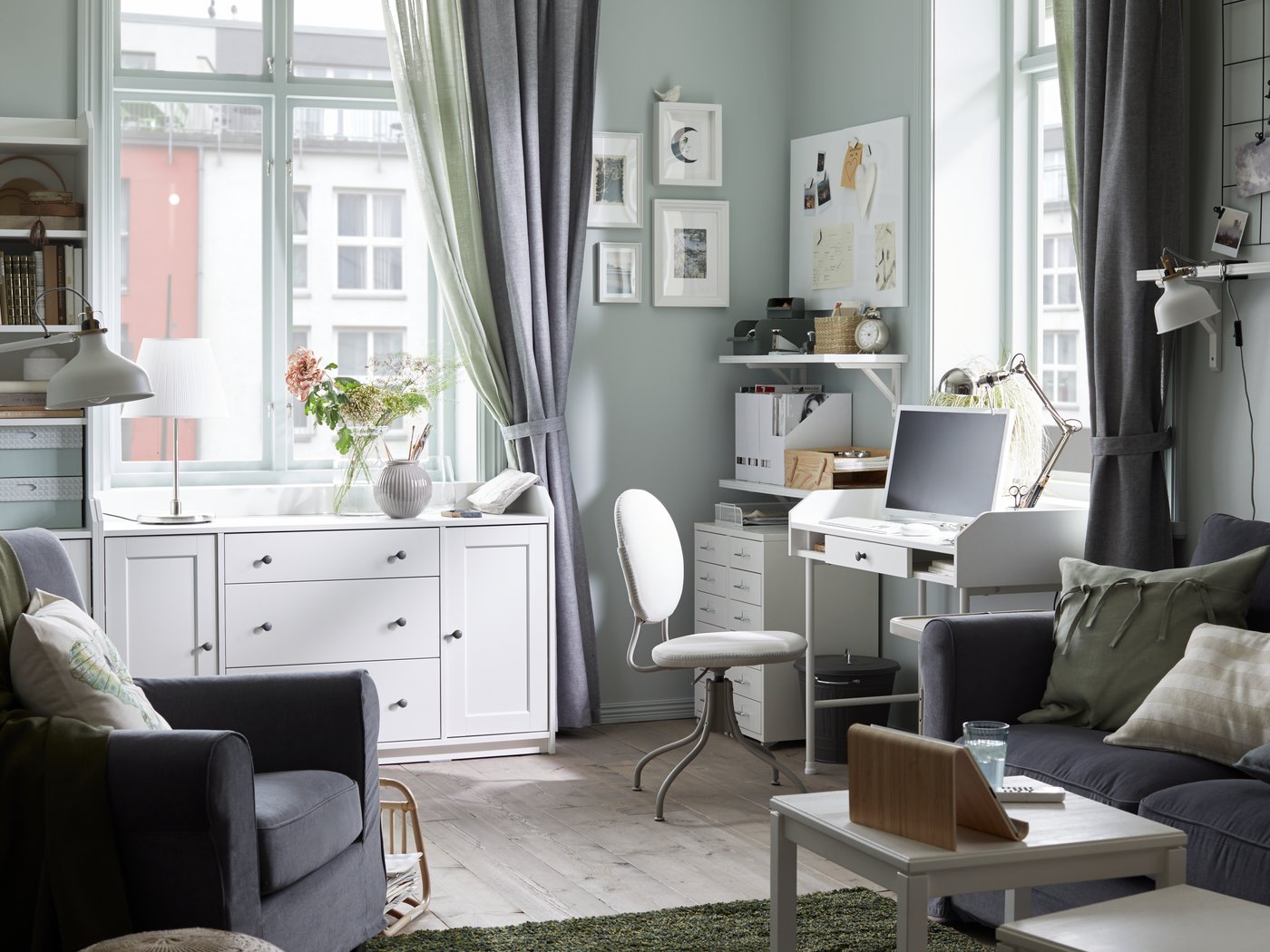 Ein Wohnzimmer in hellen Grautönen mit einer eigenen Arbeitsecke.