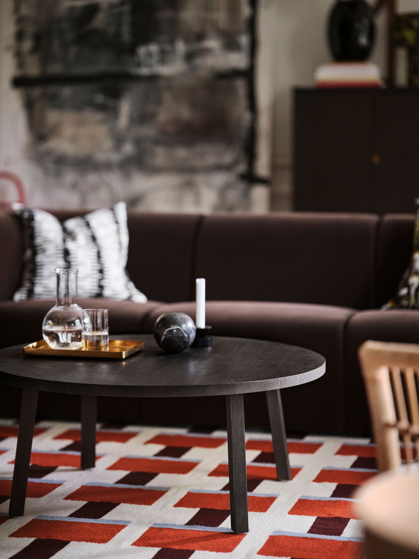 An off-white/black STOCKHOLM 2025 cushion cover in the living room