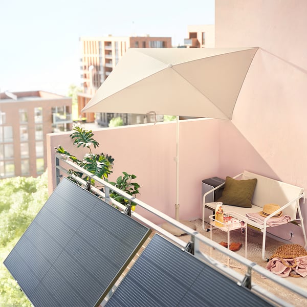 Zwei Solarpaneele hängen außen an einem Balkon.
