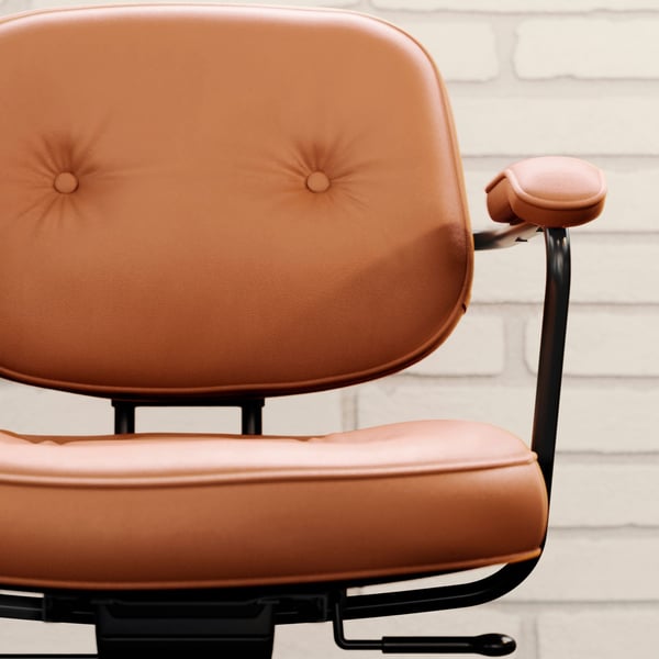 A frontal view of a ALEFJÄLL office chair in Grann golden brown against a white brick wall.
