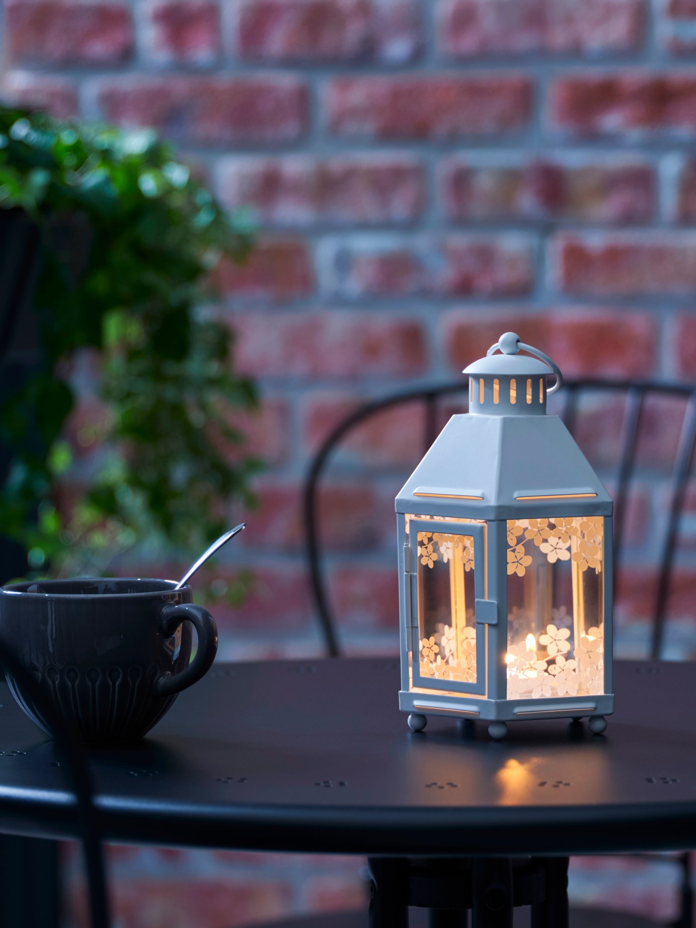 Eine weiße KRINGSYNT-Laterne für Teelichter, für den Innen- und Außenbereich