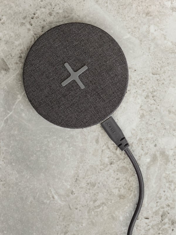 Chargeur sans fil NORDMÄRKE gris foncé sur une surface gris clair.