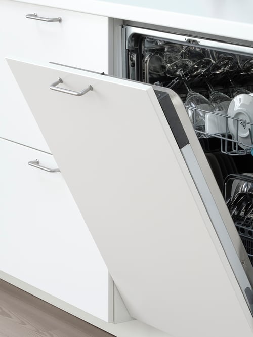 Close-up of an integrated dishwasher with a partially open white frame, and containing multiple glassware items.