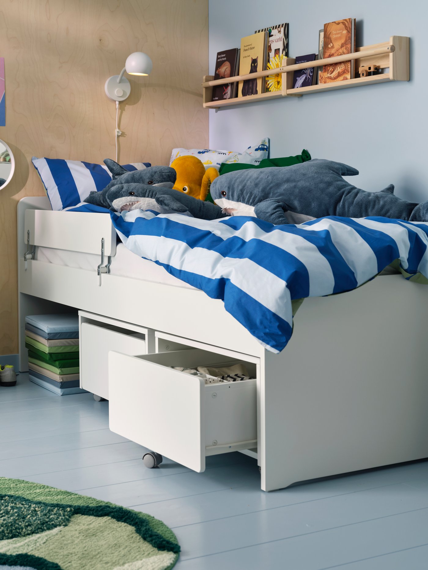 A white SLÄKT storage box with castors in the childrens room