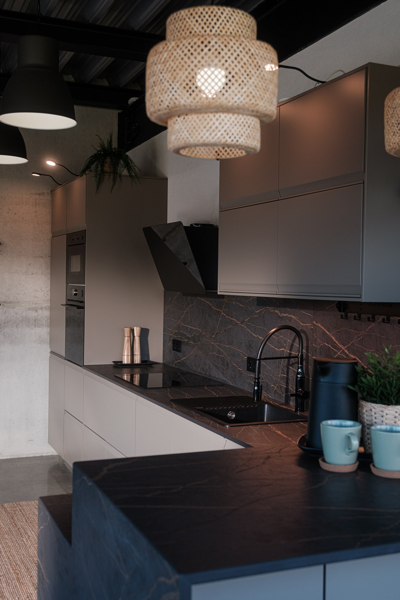 Moderne Küche mit beigen Schränken, schwarzer Dunstabzugshaube