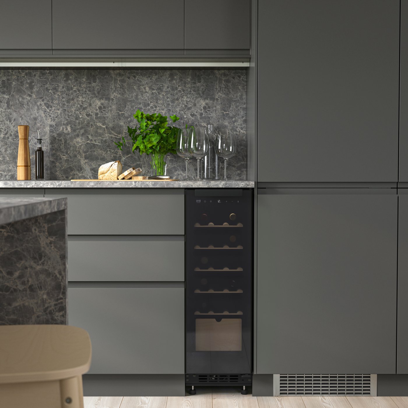 A kitchen with dark grey VOXTORP kitchen fronts and a SPELNÄS wine cooler.