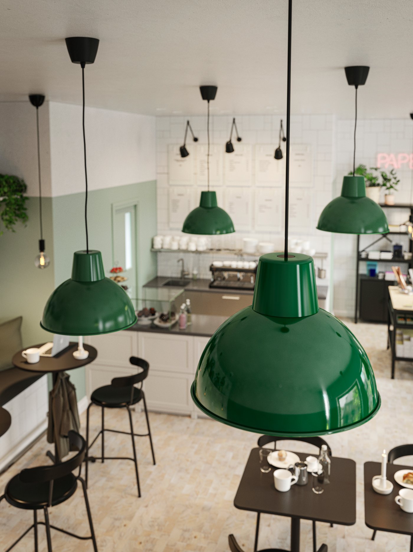 Vista superior de un comedor de restaurante donde se observan lámparas de techo verdes. Las mesas del comedor son pequeñas y cuadradas con sillas negras.