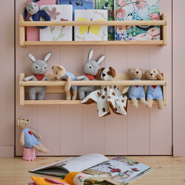 Two FLISAT wall storage on a wall above each other holding hard back books and soft toys including a FABLER BJÖRN soft toy.
