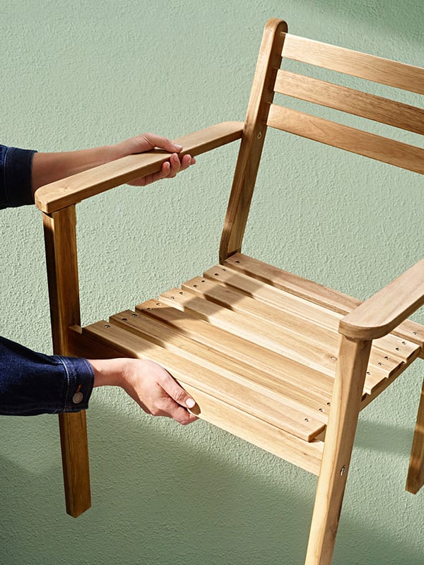 An acacia ASKHOLMEN chair with armrests, outdoor