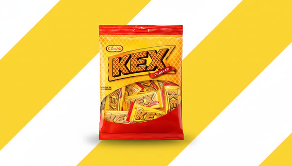Zak Kex chocoladekoekjes van Cloetta op een achtergrond met brede gele en witte diagonale strepen, centraal weergegeven in een promotionele setting.