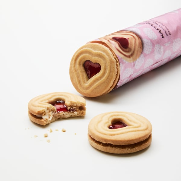 개봉된 KAFFEREP 비스킷 패키지를 클로즈업한 모습. 패키지 옆에는 온전한 비스킷 하나와 한 입 베어 문 비스킷 하나가 놓여 있는 이미지