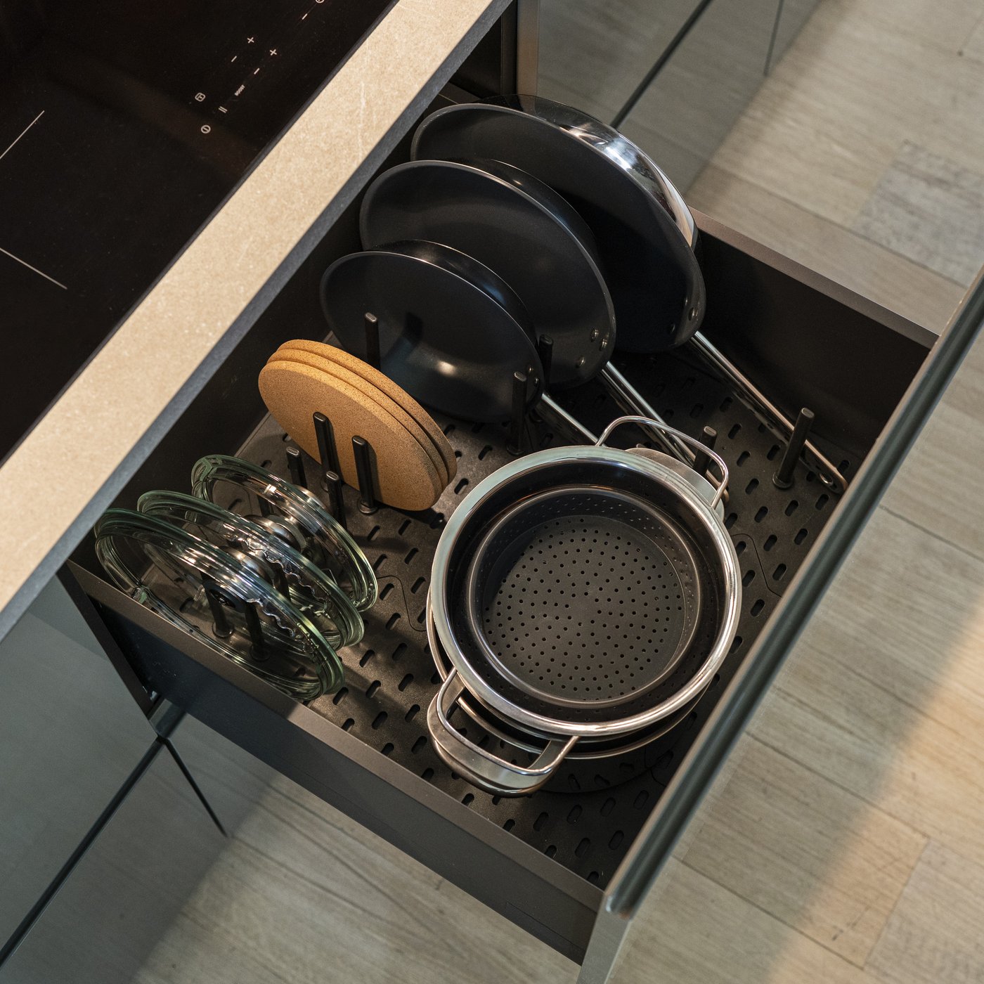 Cassetto cucina aperto con pentole, coperchi e utensili organizzati con l'accessorio divisorio UPPDATERA.