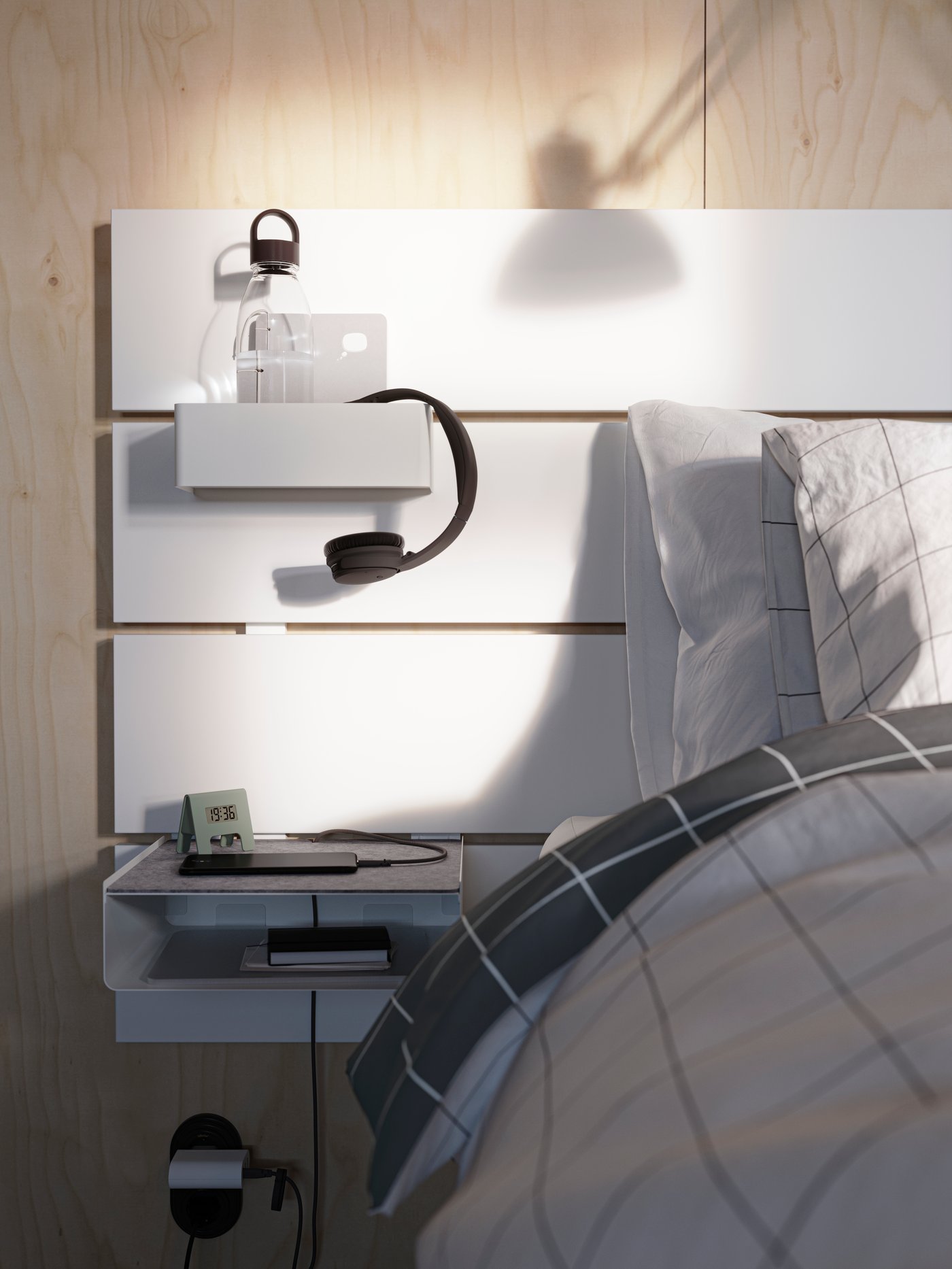 Vue de la tête d’un lit NORDLI blanc. Une bouteille d’eau et des écouteurs sont posés sur une tablette, et un téléphone intelligent sur une autre.