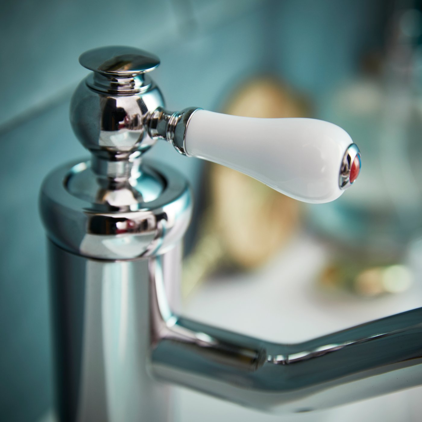 클래식한 크롬 마감의 화이트 손잡이가 달린 HAMNSKÄR 함셰르 세면기 수전을 클로즈업한 모습.