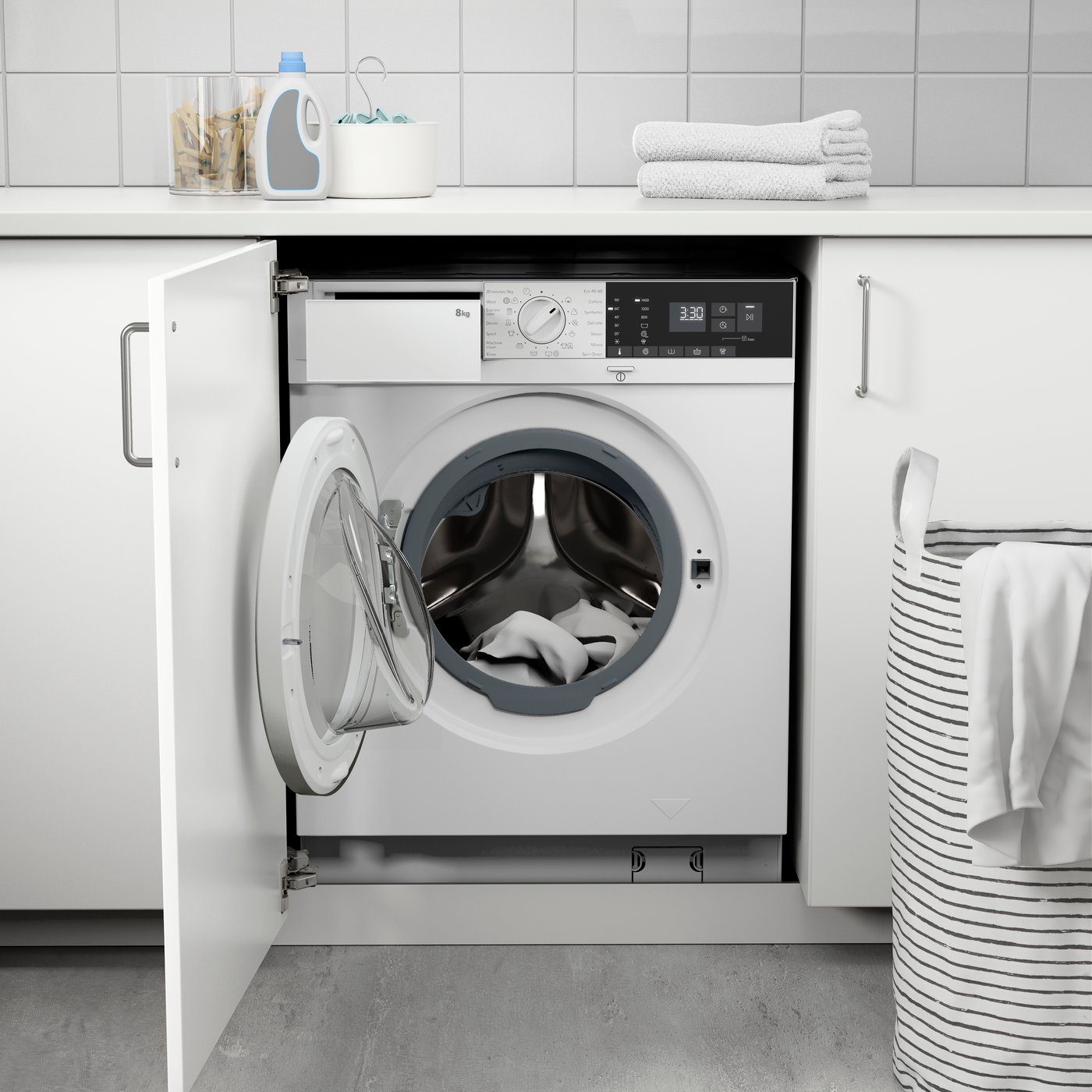 A white TVÄTTAD integrated washing machine in a white kitchen.