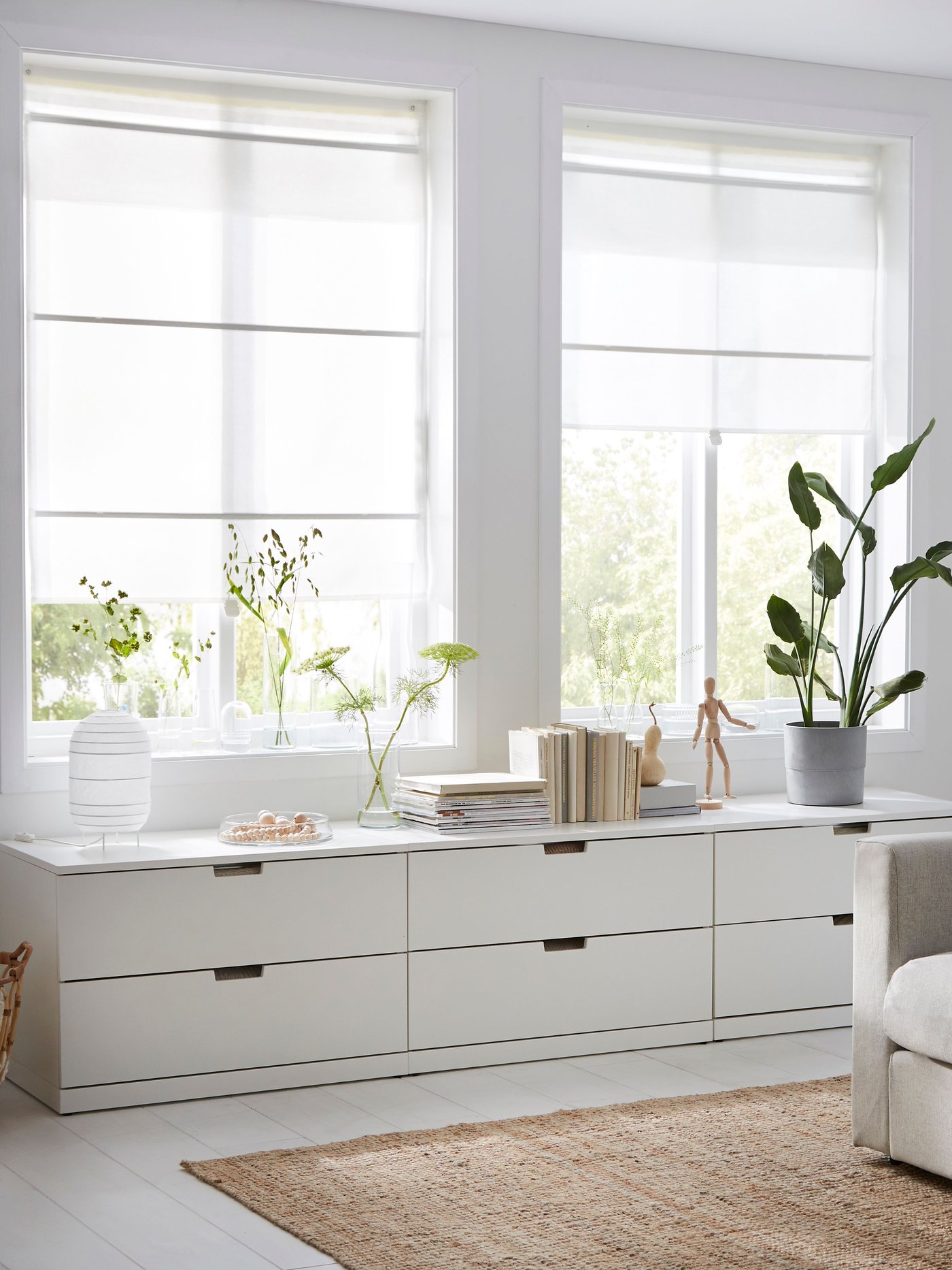 Un dormitorio con dos cómodas blancas y detrás una ventana con cortinas romanas RINGBLOMMA.