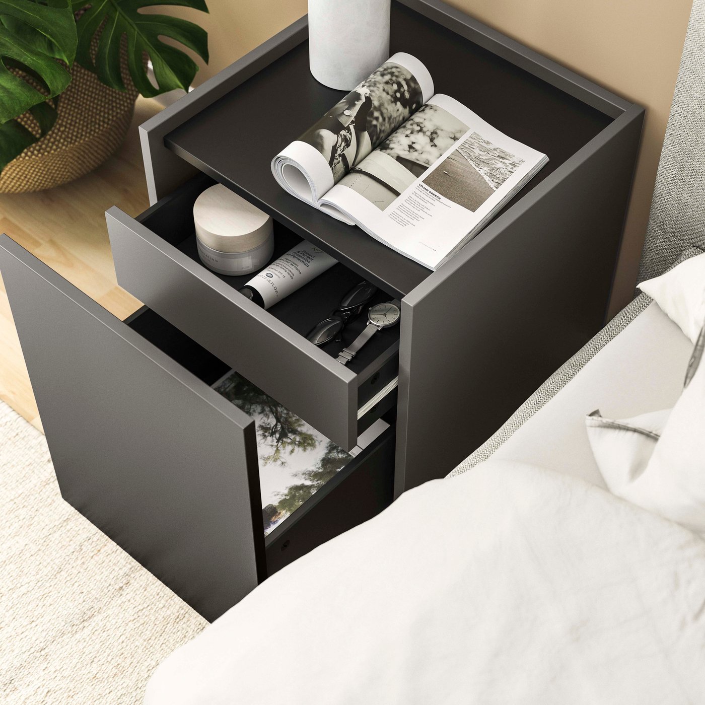 A dark grey PLÖJKER bedside table