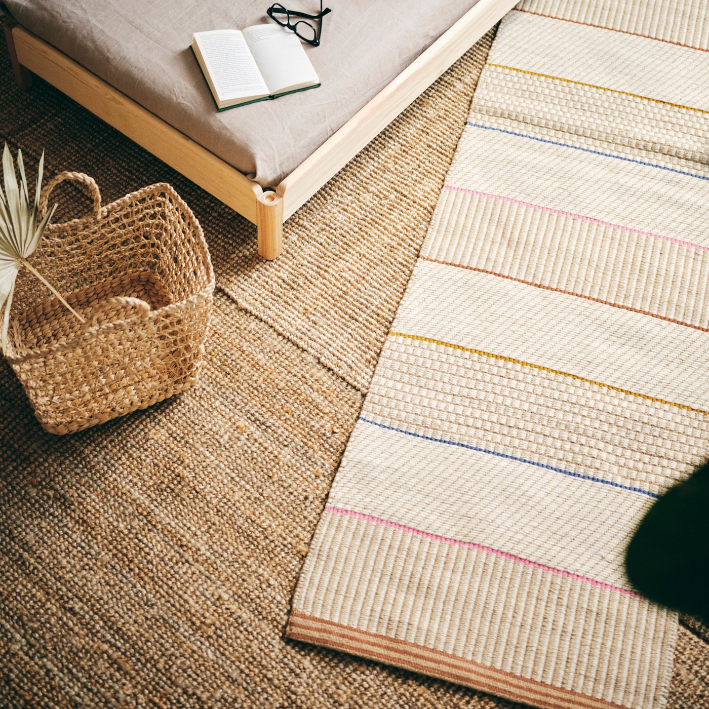 A rug next to a wooden bed. 