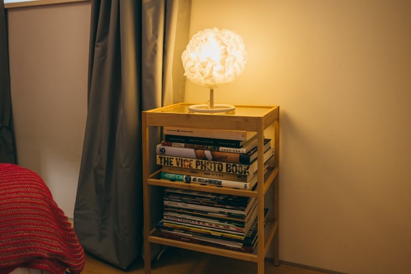 VINDKASTテーブルランプが本棚の上に置かれている。