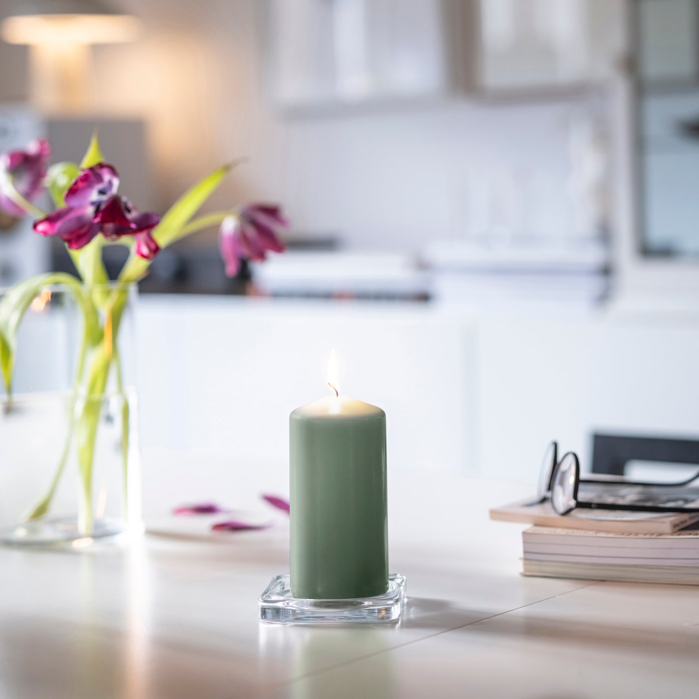 A green DAGLIGEN unscented pillar candle