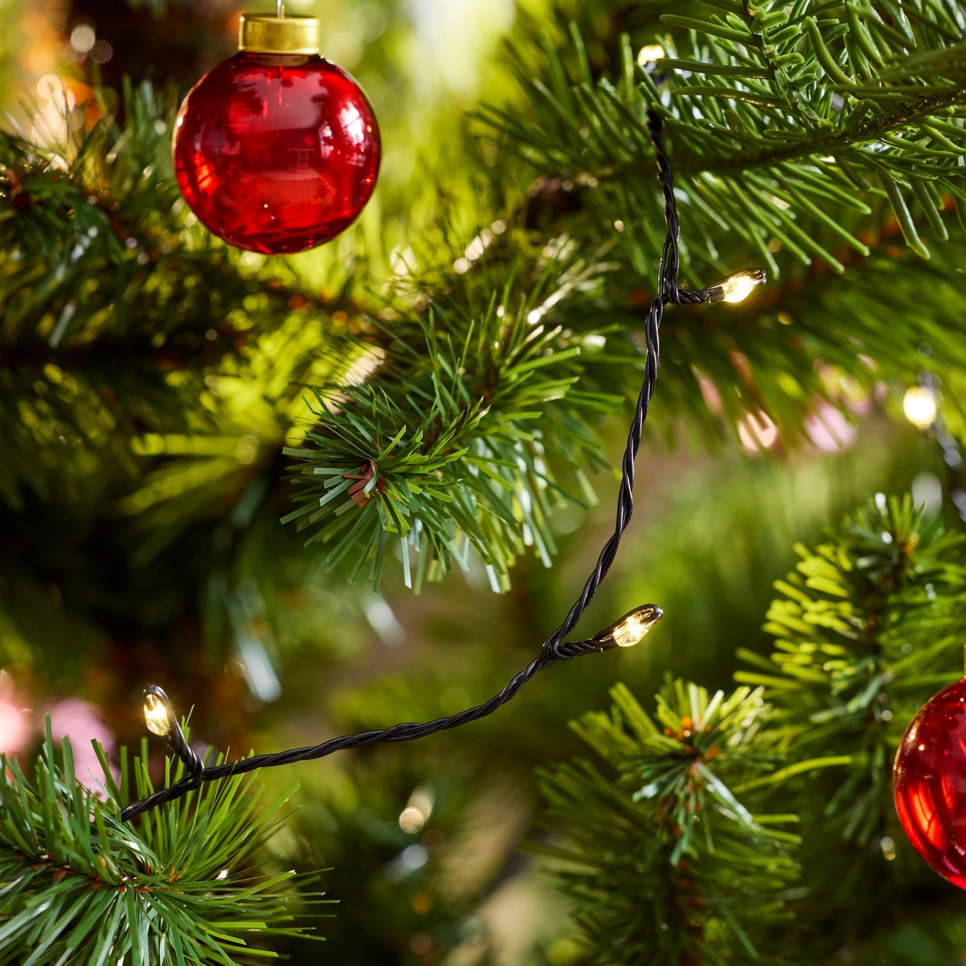 Dettaglio di alcune palline in vetro rosse della collezione VINTERFINT su un albero di Natale.