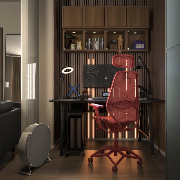 A modern black UTESPELARE gaming desk with a red STYRSPEL gaming chair in a stylish nook of a modern living room.