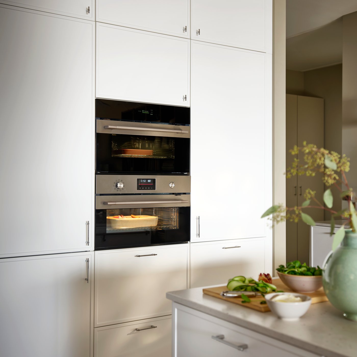 Une cuisine équipée d'un four à convection FRILLESBO couleur inox encastré dans les meubles, ainsi que d'un four mixte FRILLESBO.