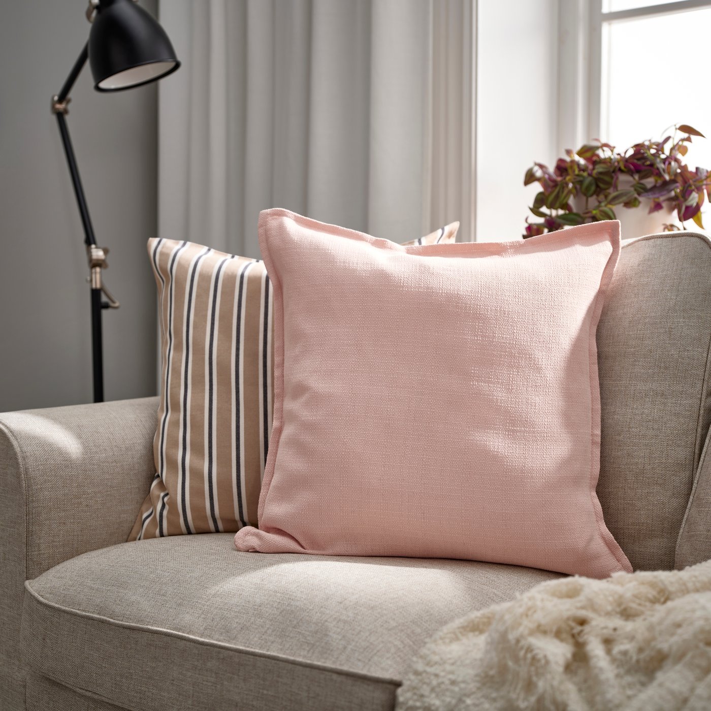A light pink LAGERPOPPEL cushion cover in the living room