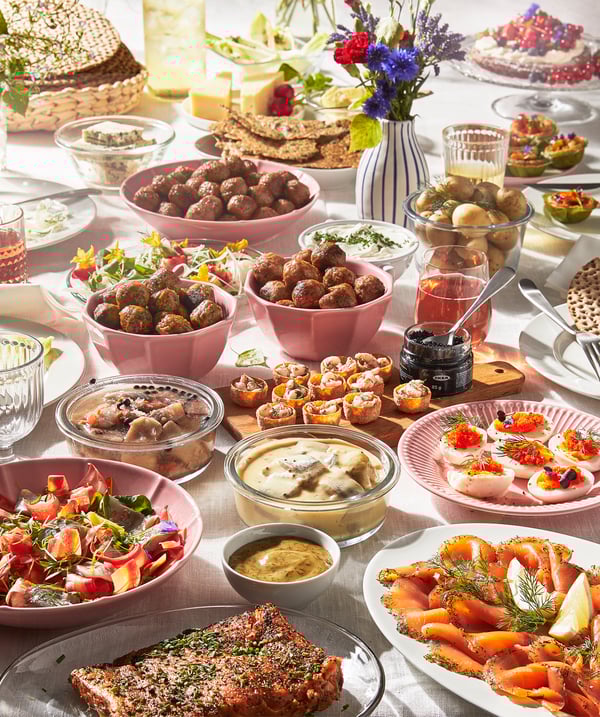 Bowls and plates in all kinds of colors containing typical Swedish snacks such as salmon, Swedish meatballs, and SILL SENAP pickled herring with mustard sauce.