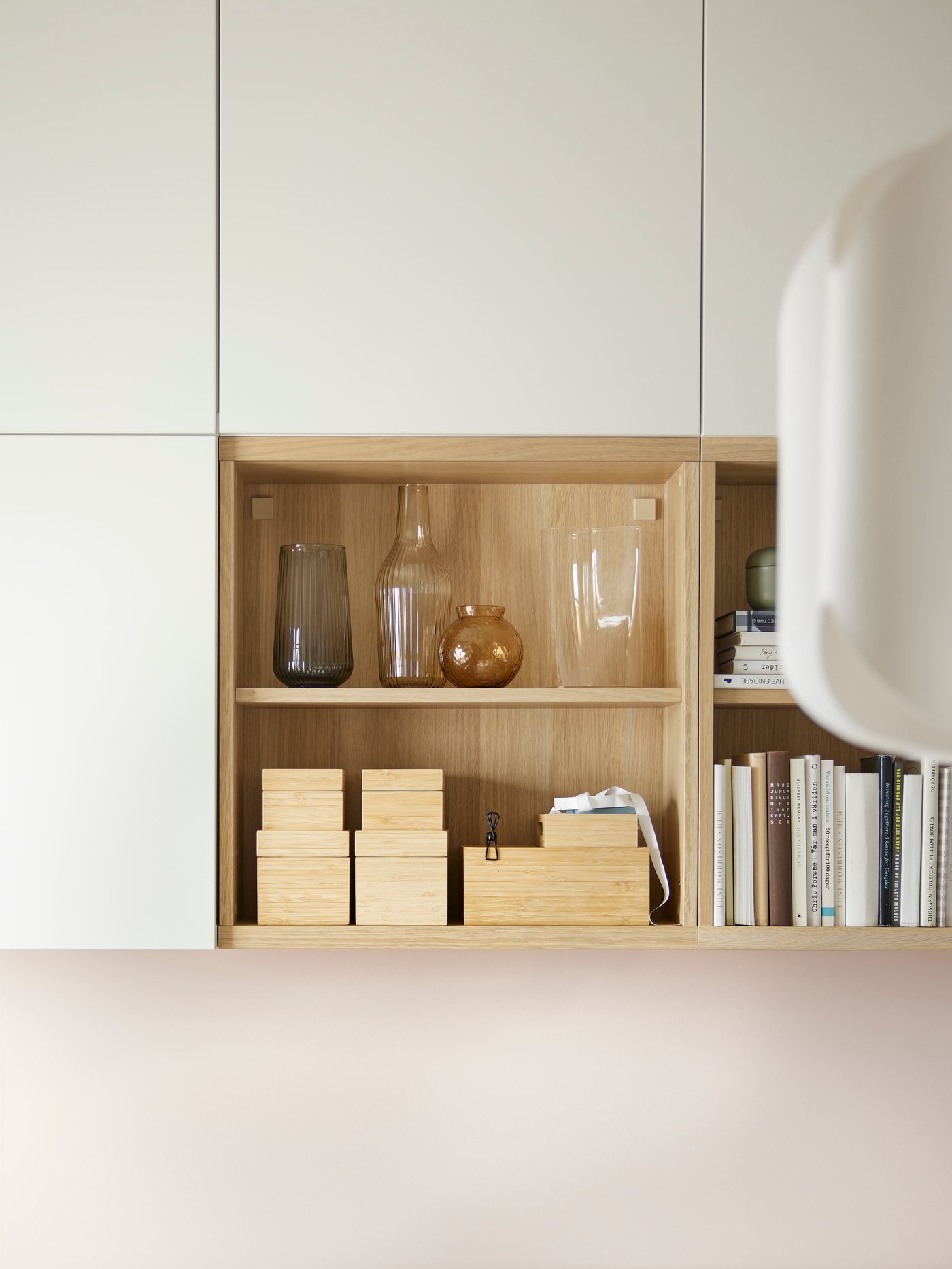 Es sind sechs BESTÅ Korpusse an einer Wand zu sehen. In zwei der Korpusse stehen Gegenstände. Die anderen vier haben weisse LAPPVIKEN Türen.