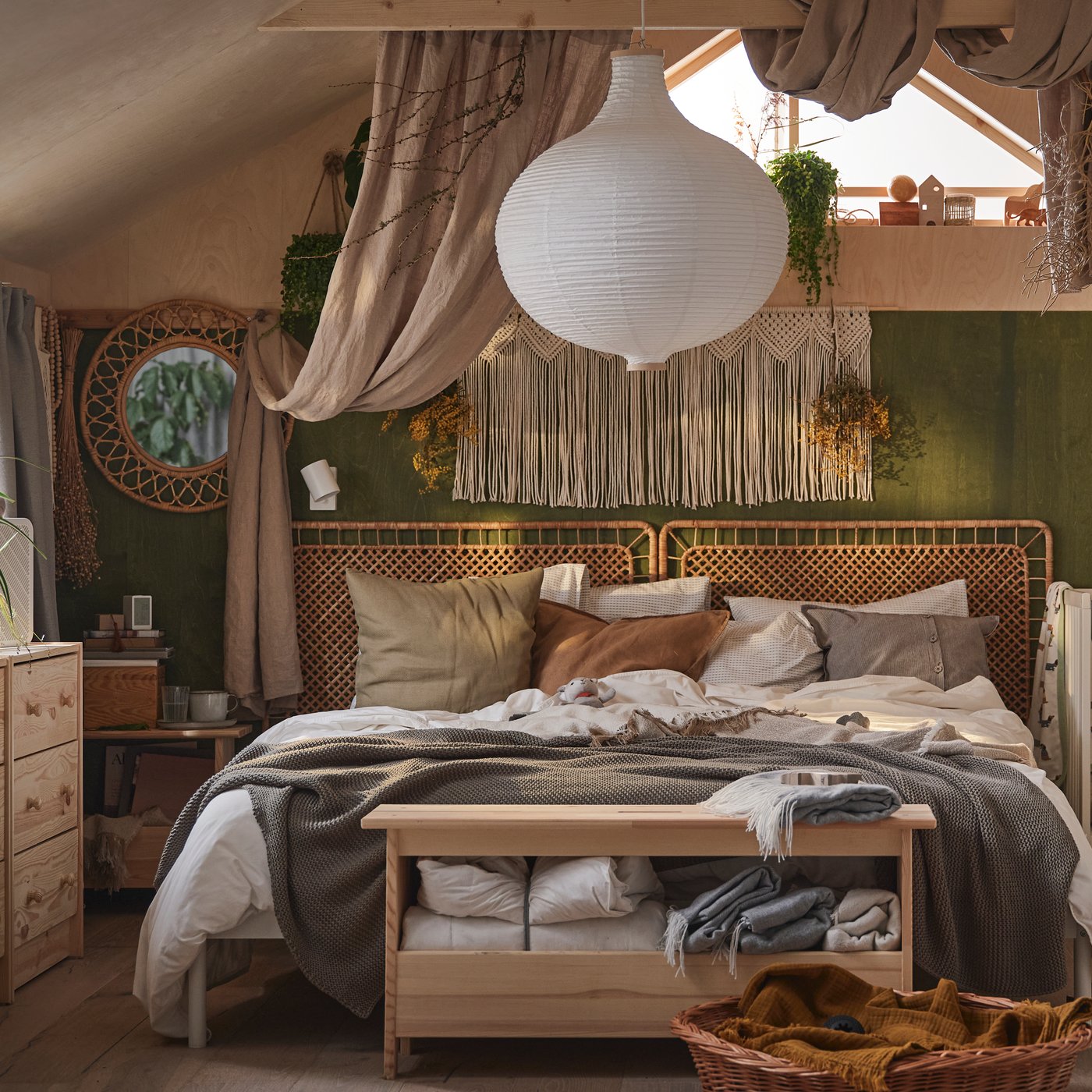 A bohemian bedroom featuring a rattan headboard, earth-toned bedding, and a paper ceiling lamp.