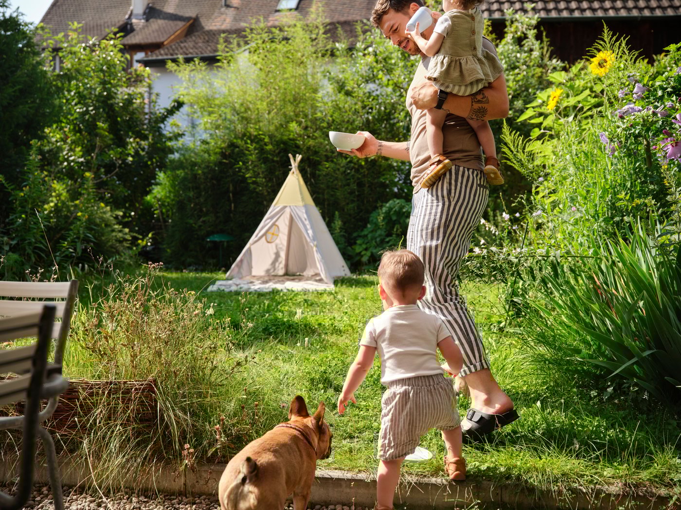 Man with 2 kids and dog in garden