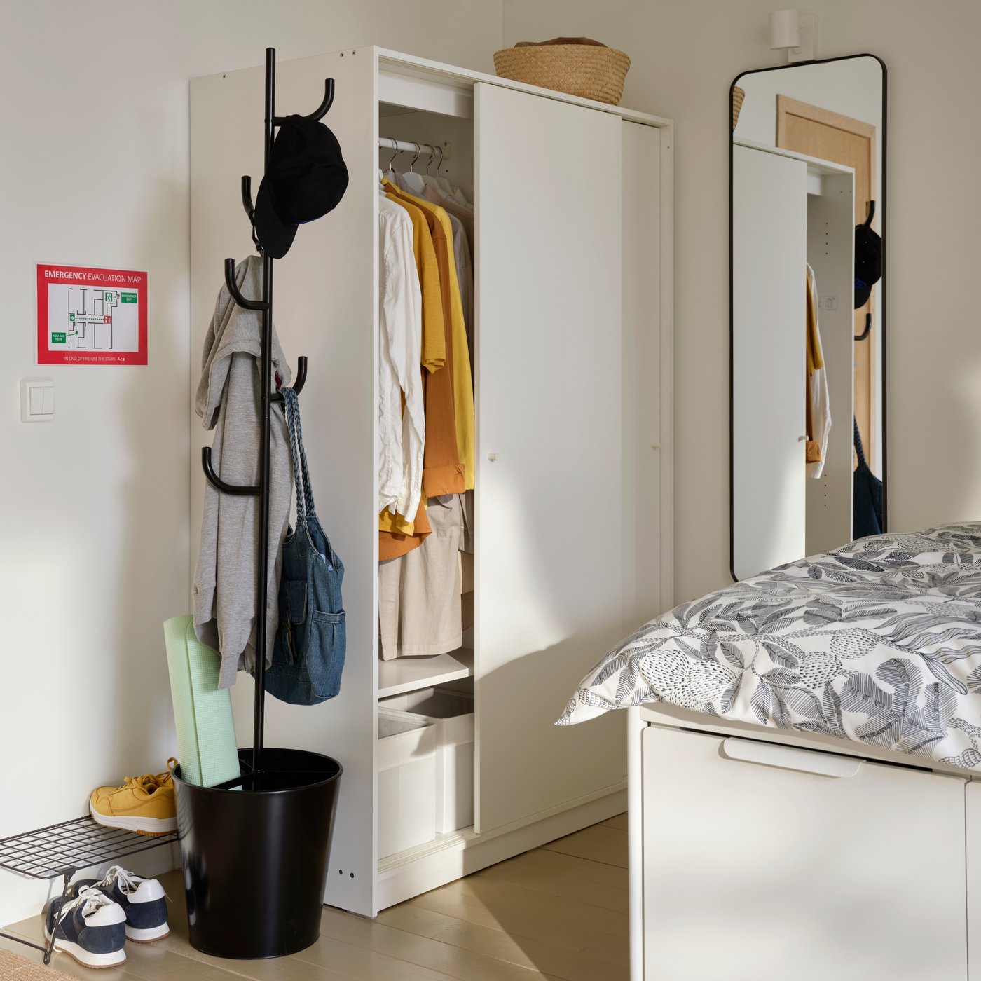 A white KLEPPSTAD wardrobe with sliding doors is in the corner of a student room rental. One door is partially open.