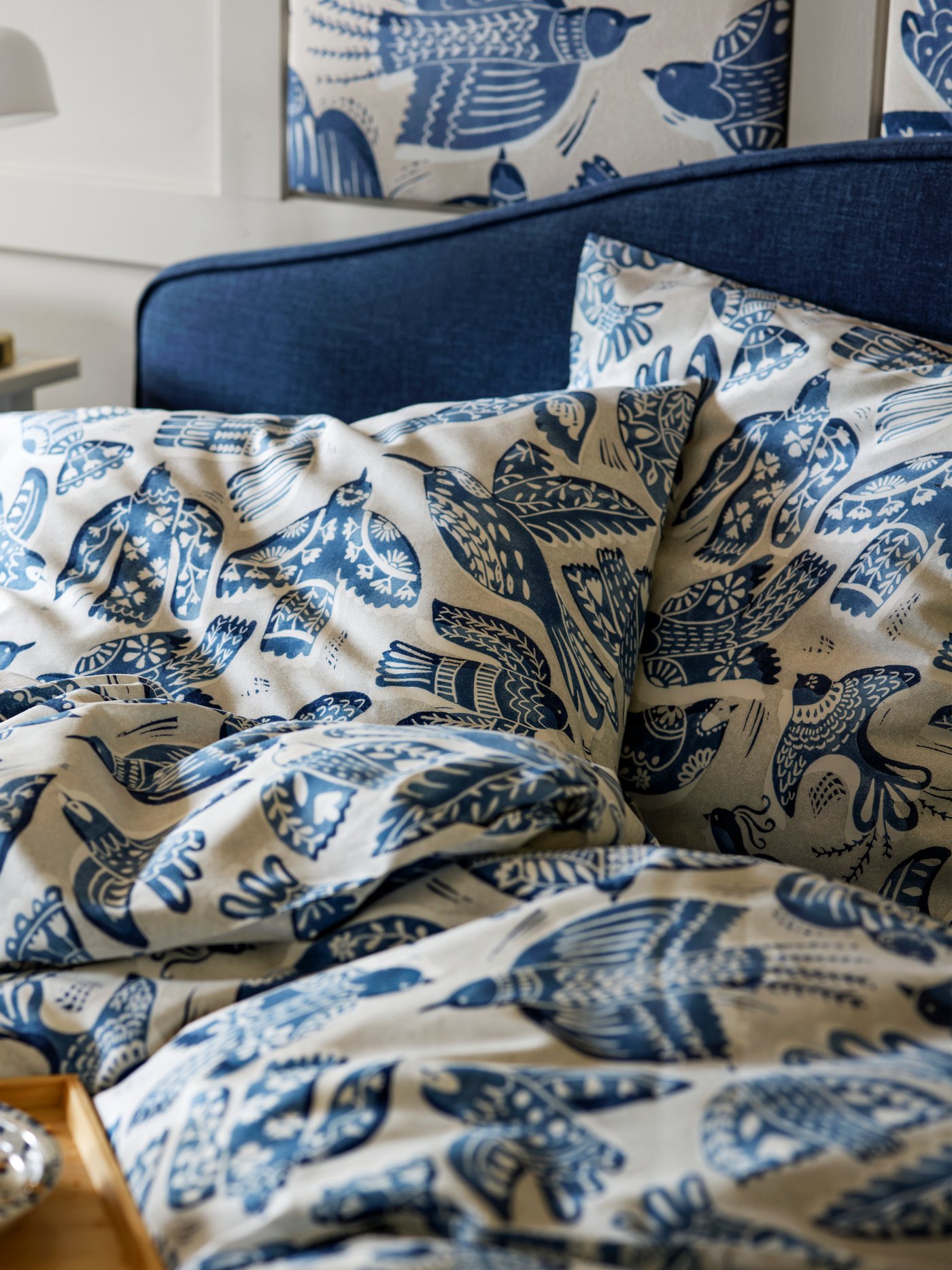 A BITTERSÖTA duvet cover and pillowcase set displayed on a bed with a matching pattern, paired with a bedside table.