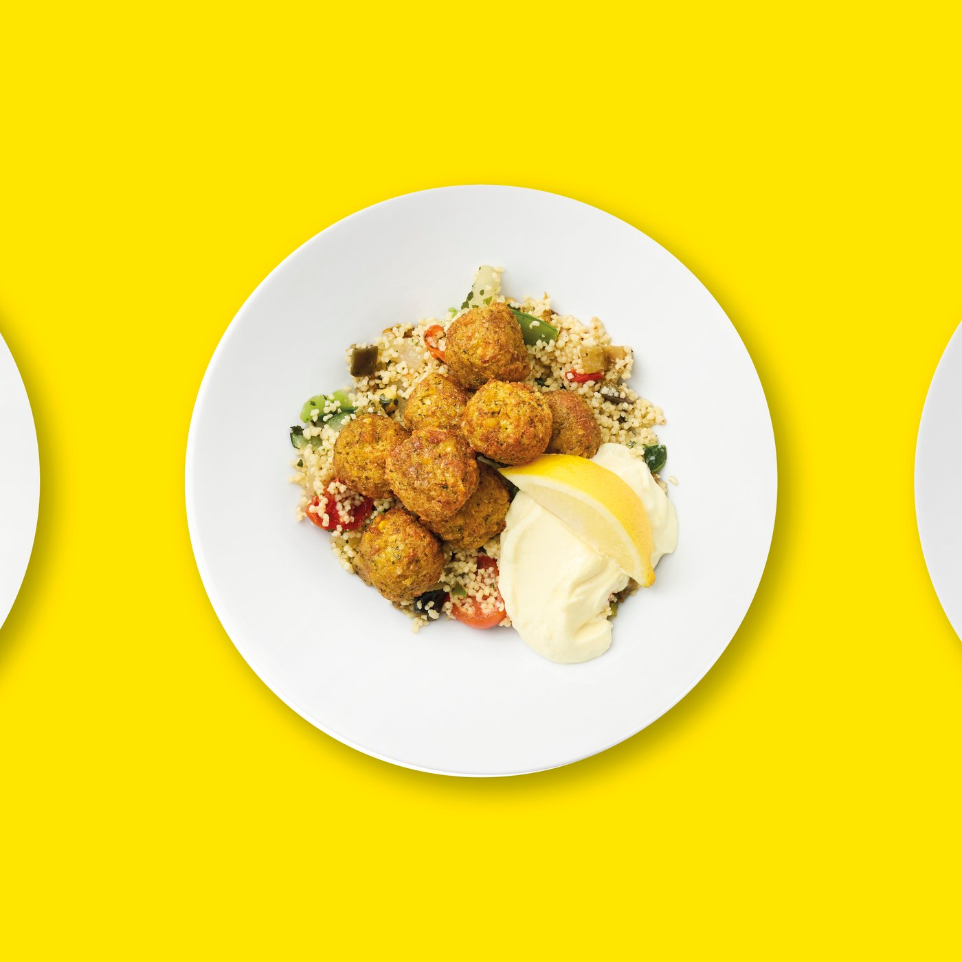 Falafel with couscous on a white plate on a yellow background