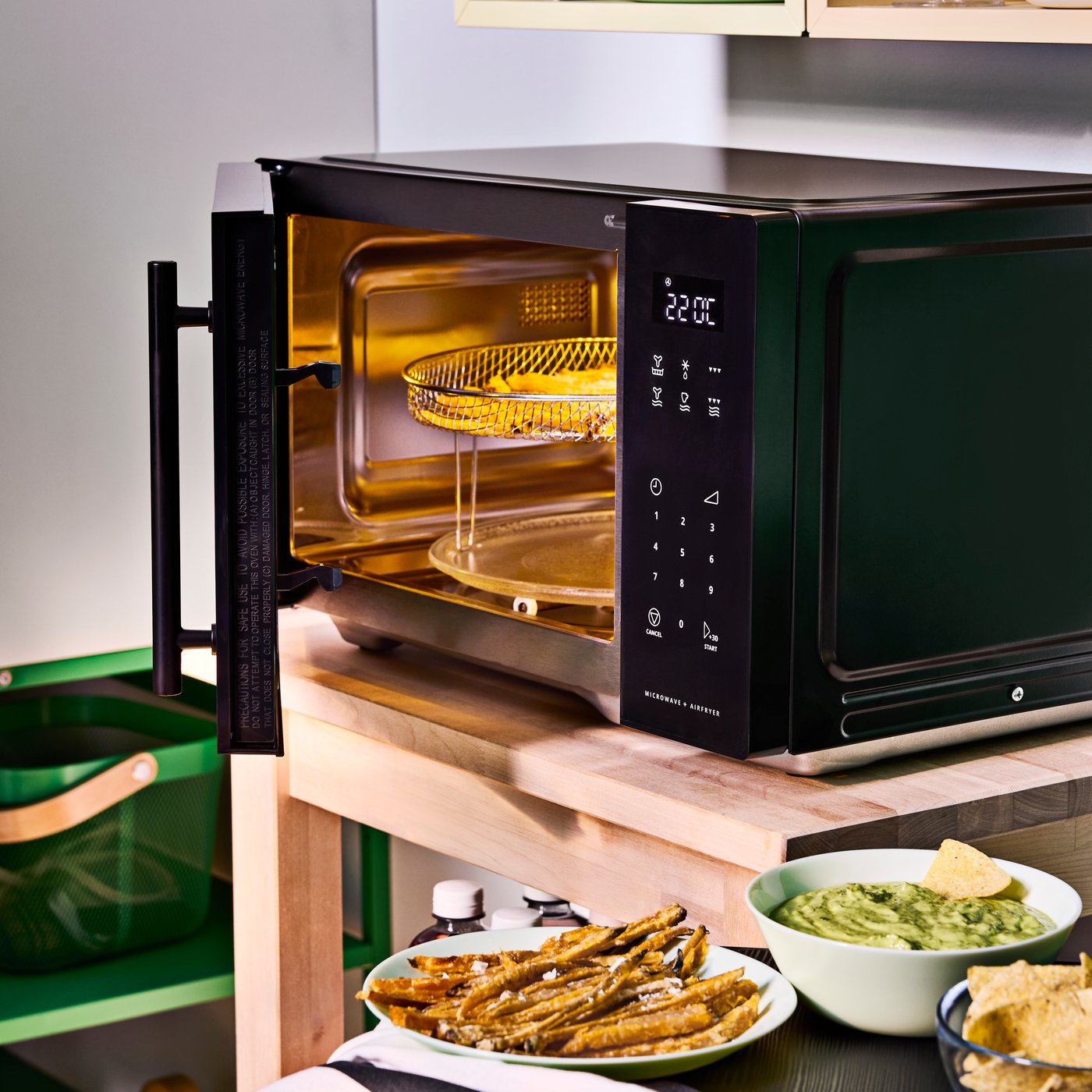 Black freestanding GÅTEBO microwave oven with air fryer function in a student kitchen.