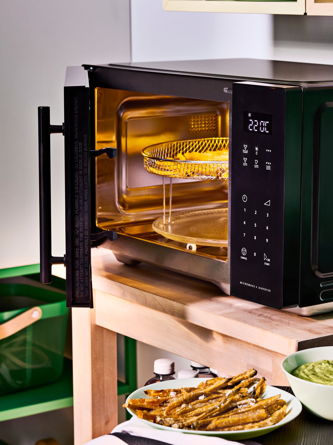 Four à micro-ondes GÅTEBO noir, autonome, avec fonction friteuse à air, dans une cuisine étudiante.