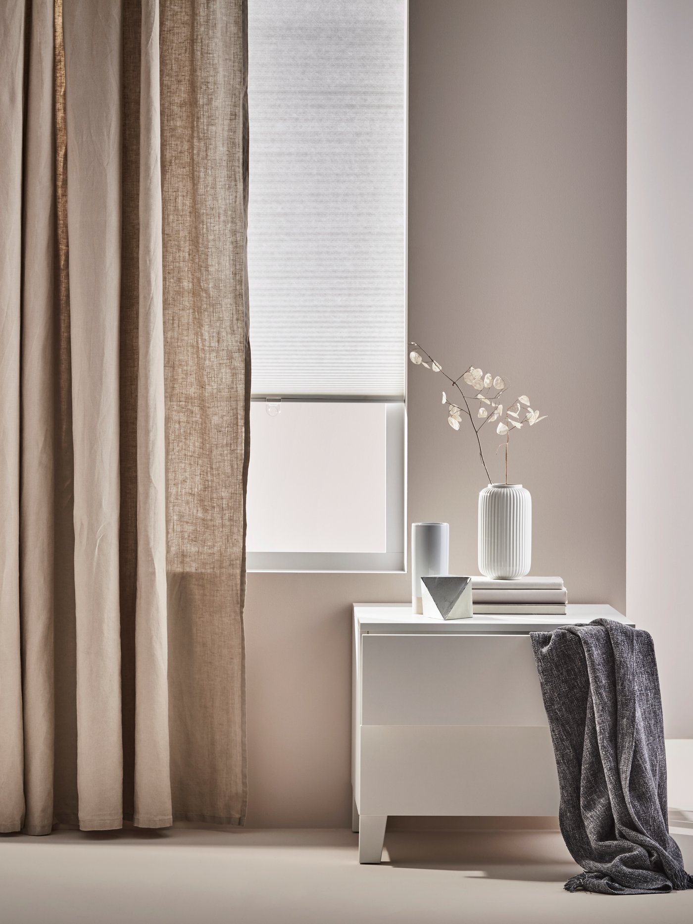 Sala de estar con la cómoda PLATSA, cortinas AINA, jarrón STILREN, estor HOPPVALS y manta INGRUN.