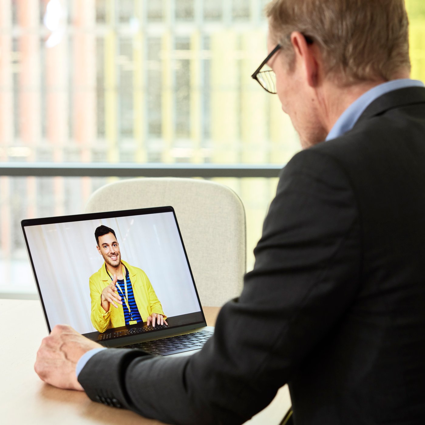 Una persona in giacca e cravatta in ufficio in videoconferenza per un progetto IKEA for Business con un esperto di IKEA