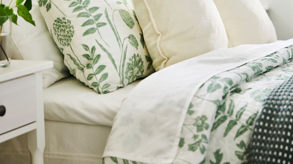 An off-white LAGERPOPPEL cushion cover in the bedroom