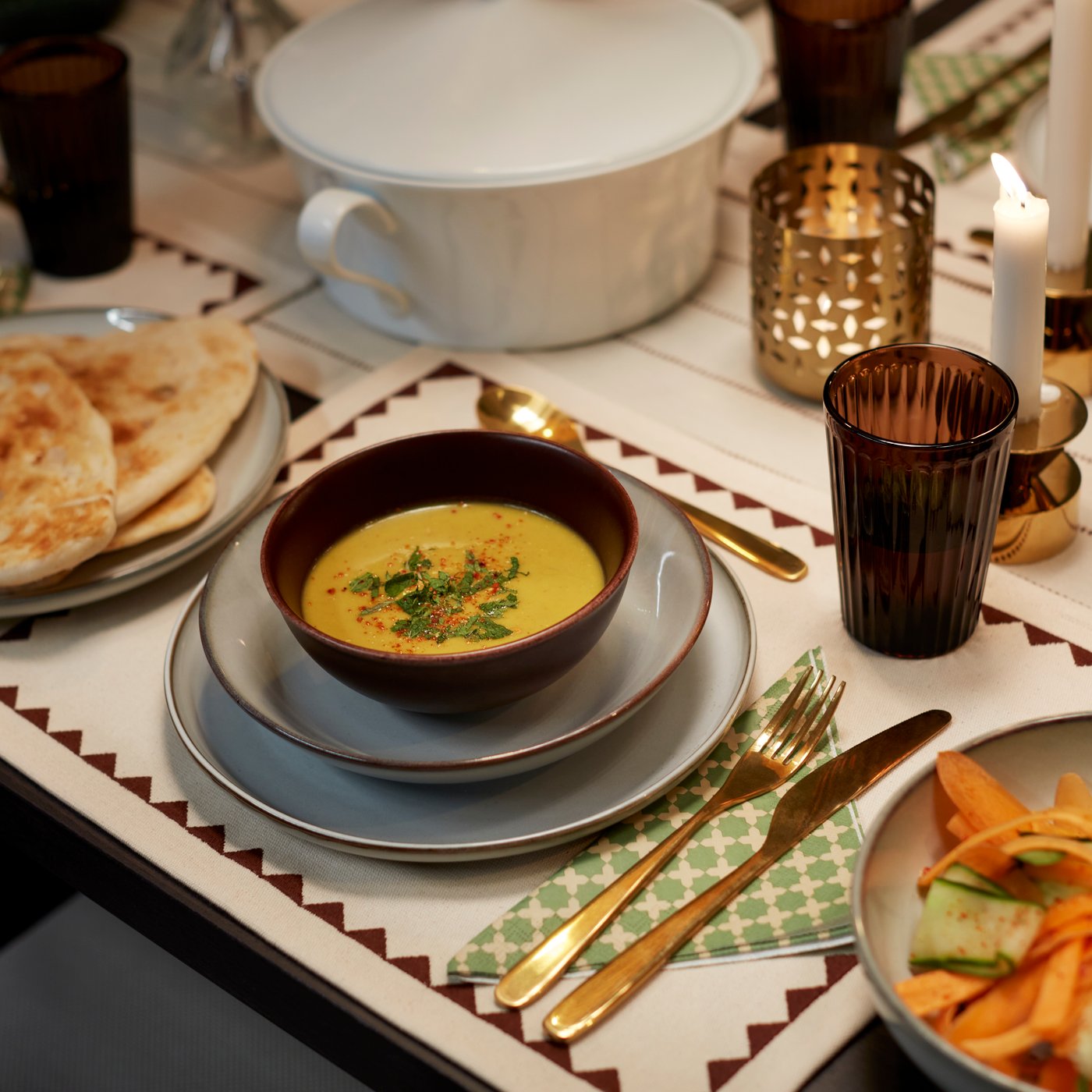 A brass-colour STOCKHOLM 2025 candlestick/tealight holder in the dining room