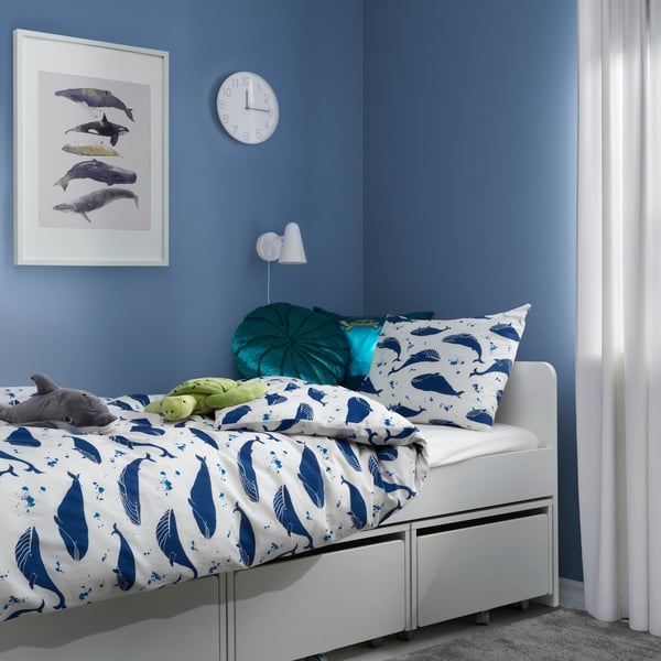 In einem blauen Kinderzimmer liegt eine BLÅVINGAD Bettwäsche mit Walen auf einem SLÄKT Bett
