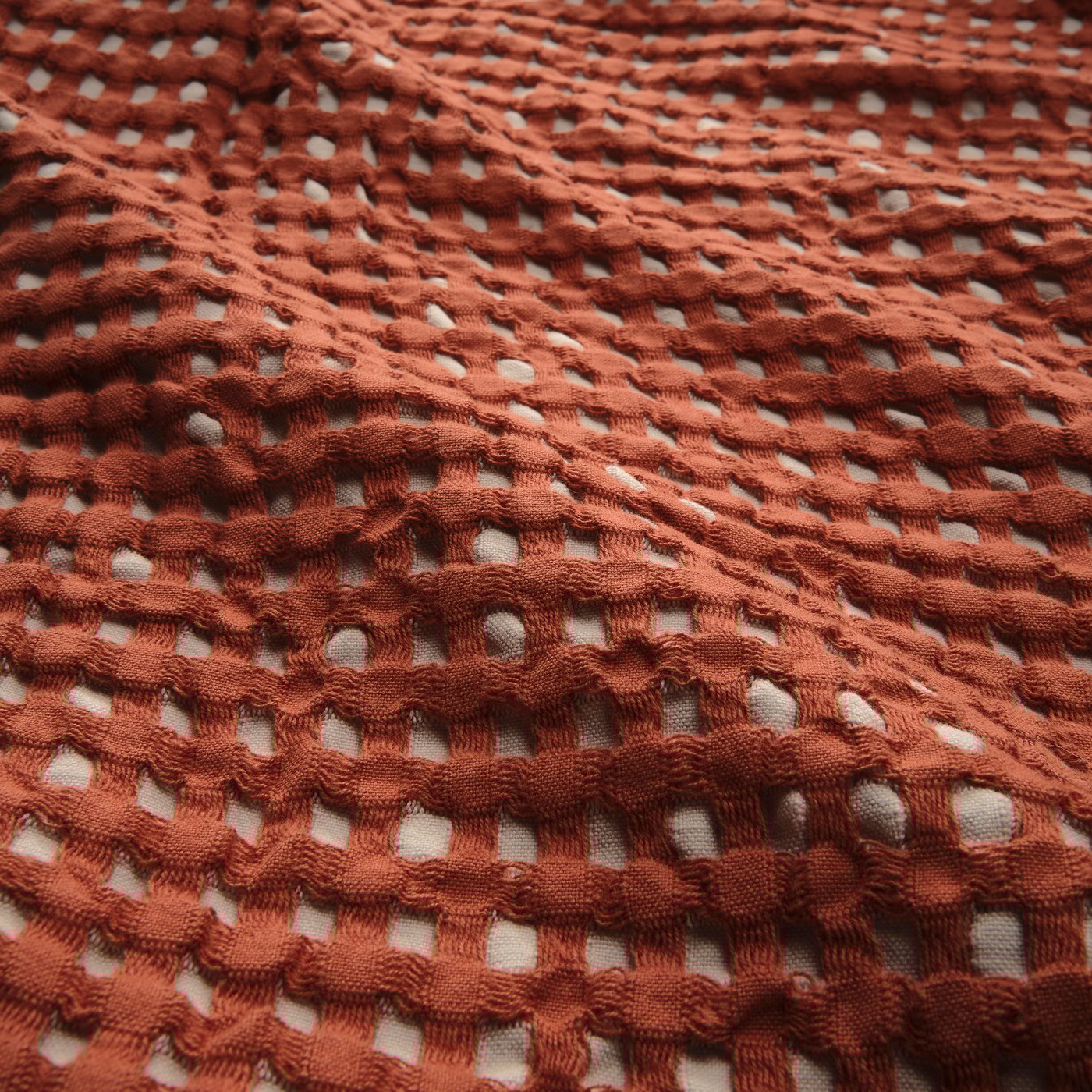 A red-brown/beige PELARTUJA bedspread