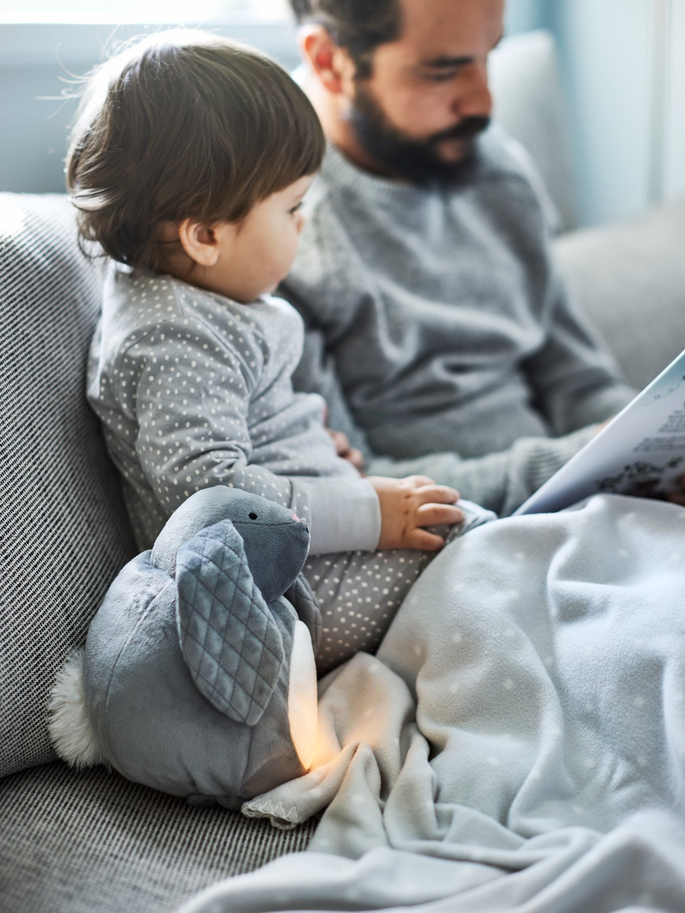A grey rabbit/battery-operated PEKHULT soft toy with LED night light in the childrens room