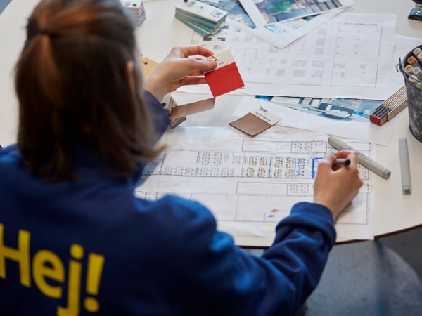 An IKEA co-worker with a blue jumper designing a space