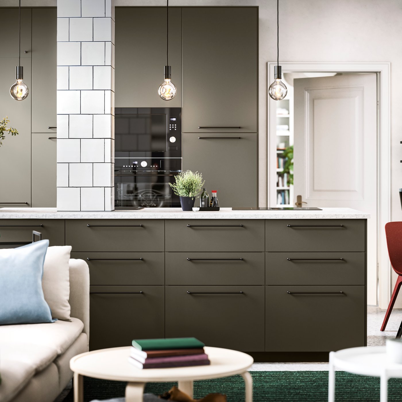An open kitchen with brown-beige HAVSTORP kitchen fronts, black BAGGANÄS handles and anthracite high frames with shelves.