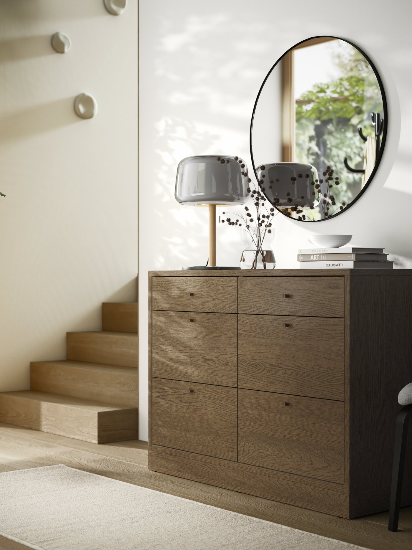 TONSTAD chest of 6 drawers, a round mirror and a table lamp are in a passageway by stairs leading to an upper level.