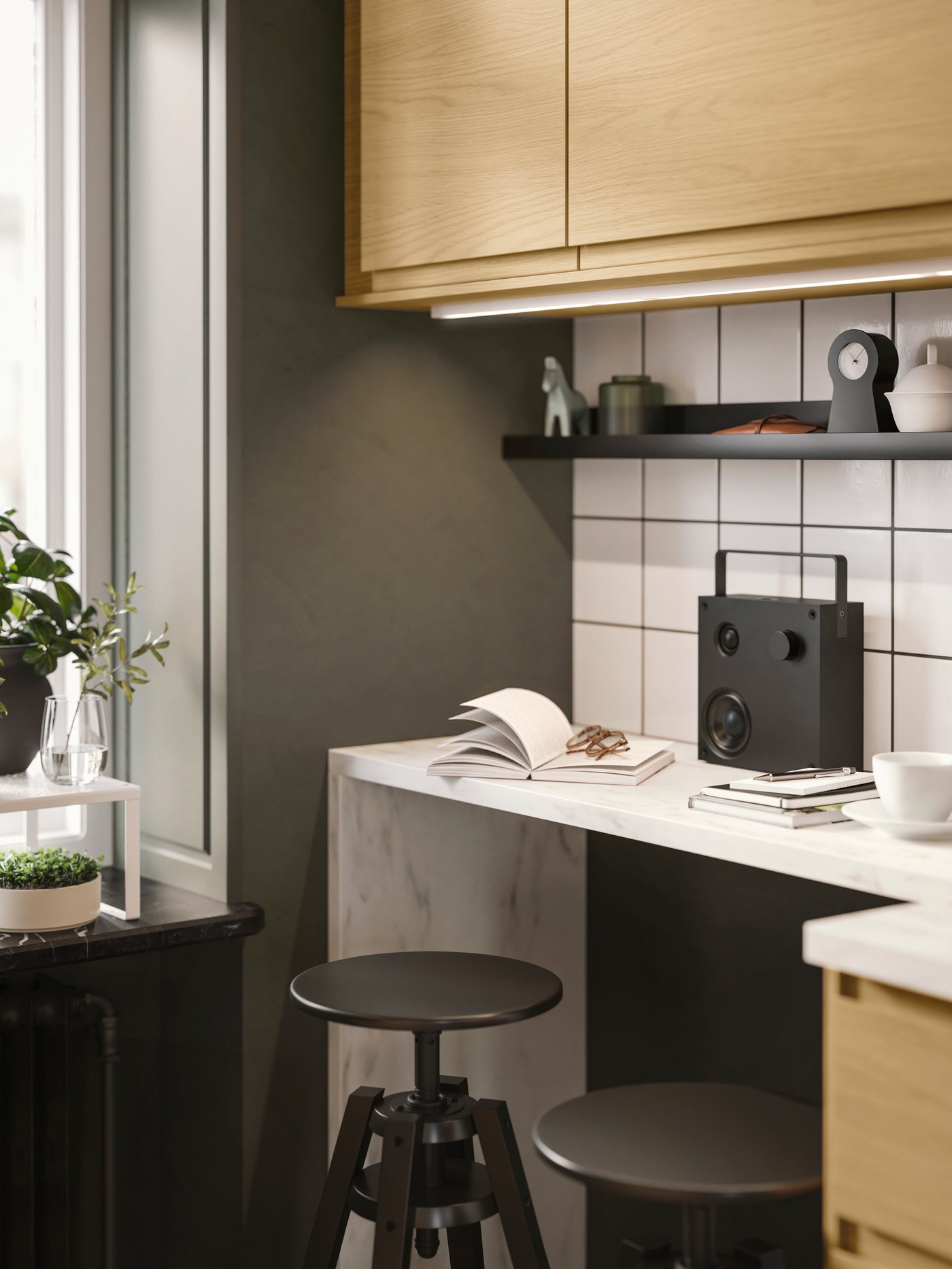 A kitchen with VOXTORP fronts with oak effect and integrated handles has two black DALFRED bar stools next to the worktop.